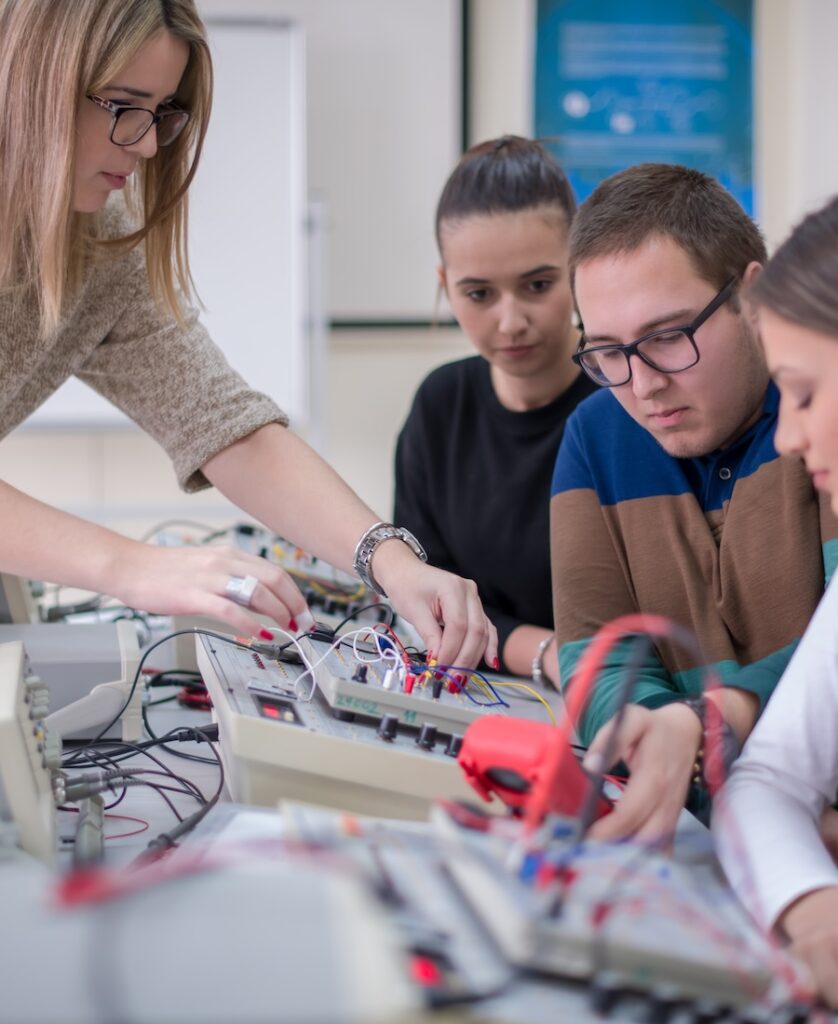 Group of young students doing technical vocational practice with teacher in the electronic classroom, Education and technology concept
