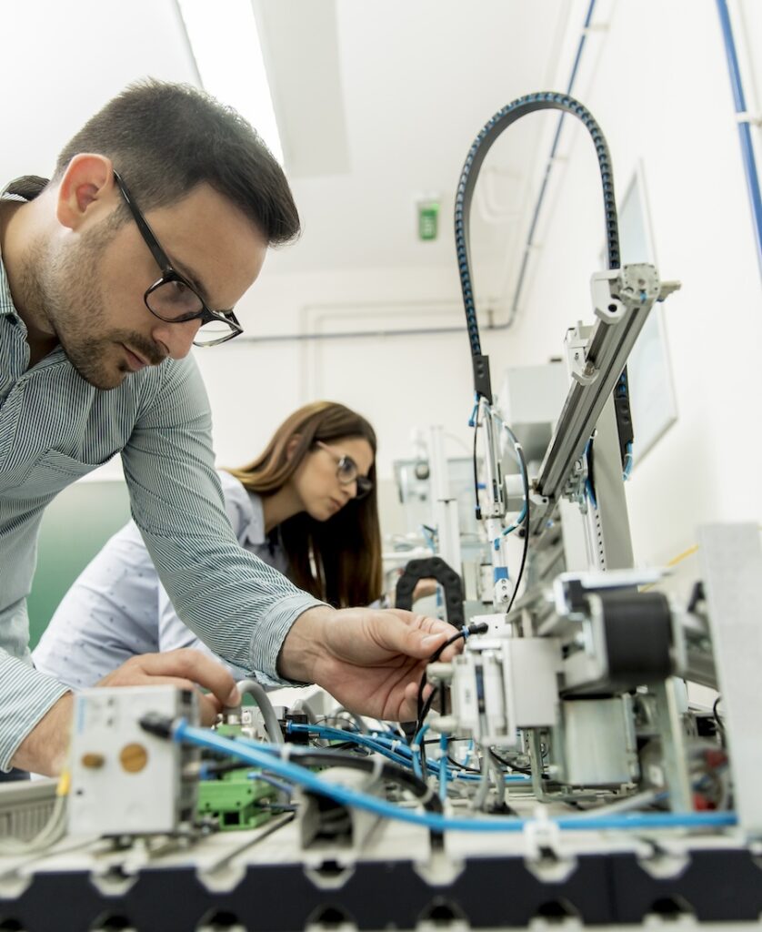 Young couple of students working at robotics lab